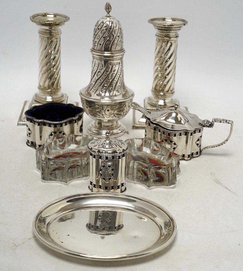 A 1970's silver sugar caster, a modern silver three piece condiment set, a silver oval dish and four other items including a pair of silver plated dwarf candlesticks. Condition - poor to fair